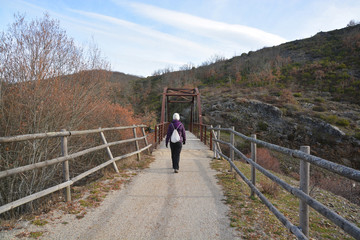 caminante cruzando un puente colgante