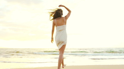 Happy Girl Having Fun at the Beach on Luxury Island at Sunset. Model Girl Spinning in SLOW MOTION Splashing Feet Wet. 