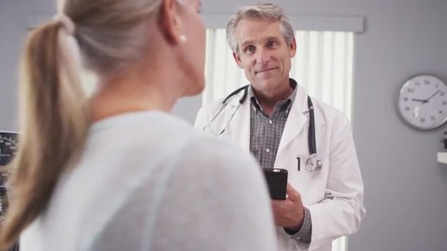Middle-aged female patient talking with medical doctor