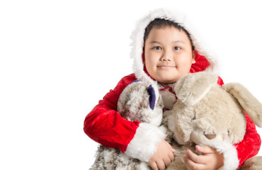 Little Asian fat boy in santa costume hugging rabbit doll on chr