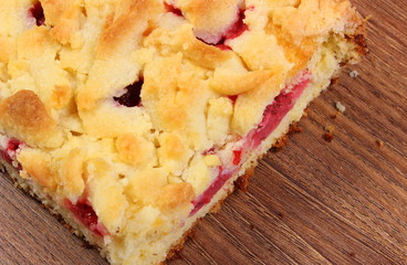 Fresh baked yeast cake with strawberries on wooden table