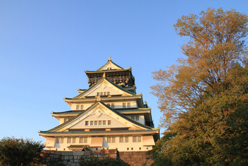 Fototapeta premium Osaka castle and trees with sunset in Japan