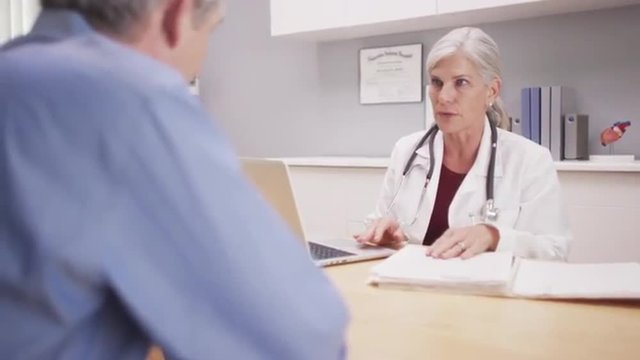 Beautiful mature medical doctor consulting with patient