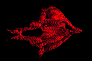 The  body of woman with red pattern and its reflection