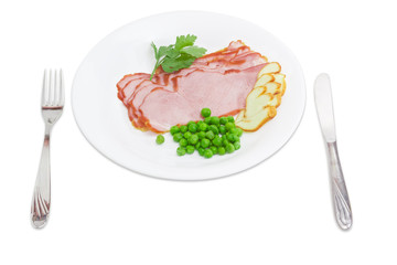 Sliced ham and smoked cheese, green peas, fork and knife