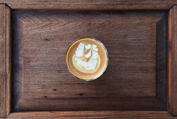 Fototapeta na wymiar cup of latte art coffee on wooden background