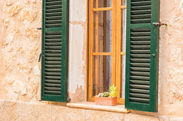 Fototapeta na wymiar Holzfenster mit Fensterläden grün offen