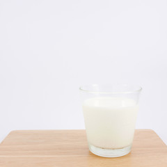 The glass of fresh milk on the wooden board.
