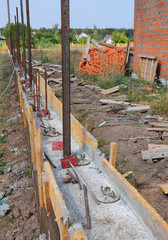 Fototapeta premium Building concrete foundation for new fence with metal supports.