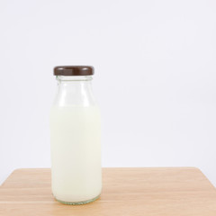 The bottle of fresh milk on the wooden board.