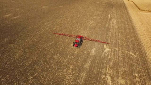 Tractor sprays which protect against pests at a farmer's field corn, aerial shot