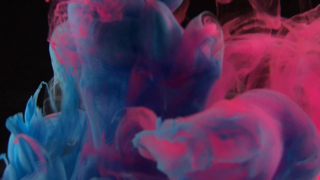Blue pink clouds of ink in liquid isolated on black