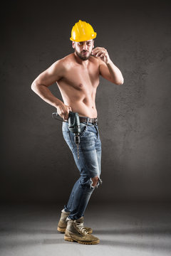 Portrait of attractive shirtless workman with drill