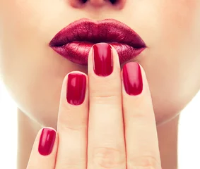 Foto auf Acrylglas Maniküre Schönes Modell zeigt rote Maniküre auf den Nägeln. Rote Lippen. Luxuriöser Modestil, Manikürenagel, Kosmetik und Make-up.