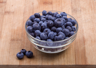fresh blueberries in white bowl on wood table