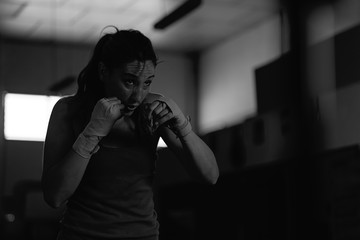 Professional female boxer practicing strokes in the gym
