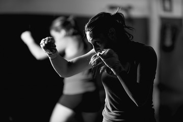 Professional young female boxer practicing strokes