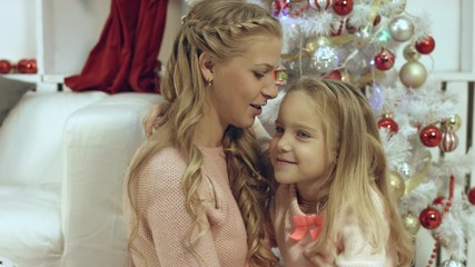 Happy mother and daughter near the a Christmas tree - Powered by Adobe