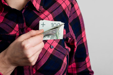 Kobieta wyciąga polskie pieniądze z kieszeni