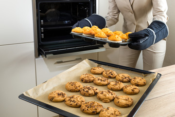 Double burden: business woman baking cupcakes in the kitchen