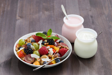 fruit salad and yoghurts on a wooden table