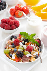 fruit salad in a bowl and various yoghurt, top view