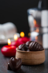 Chocolate candies with coffee and candles