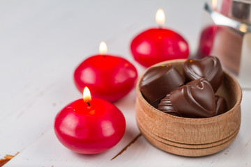 Chocolate candies with coffee and candles