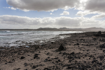 Dark landscape of rocks and ocean surf.