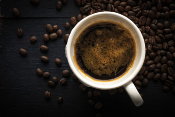 Obraz na płótnie Canvas Cup of coffee with coffee beans top view