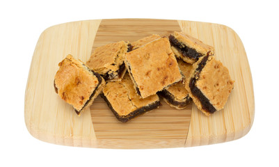 Small square fig bar squares on a wood cutting board