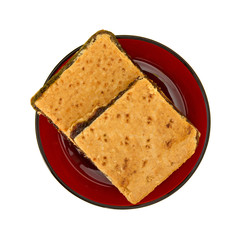 Two homemade fig bar squares on a red plate