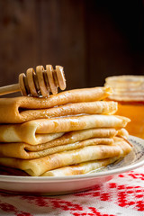 Stack of crepes or pancakes served with honey (Russian cuisine - blini, blintzes, national food for Maslenitsa)