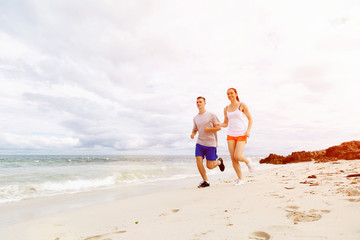 Runners. Young couple running on beach