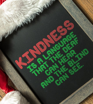 Kindness Is a Language That the Dead Can Hear And The Blind Can See written on blackboard with santa hat