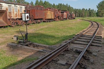 Railway switch with old rusty waggonage with steam locomotive, carriage and wagon in background....