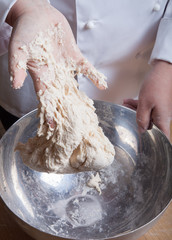 Woman's hands knead dough. Selective focus
