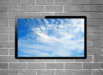 Blank screen LCD tv with blue sky screen hanging on a wall