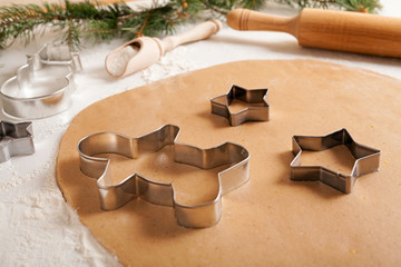 Gingerbread cookies dough preparation recipe with man shape and star forms, cinnamon rolling pin, flour on white kitchen table. Traditional homemade christmas dessert
