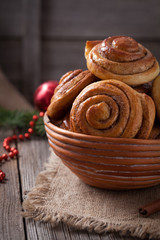 Sweet cinnamon bun rolls or kanelbullar homemade delicious dessert with spice on vintage woonde table. Traditional swedish baked pastry