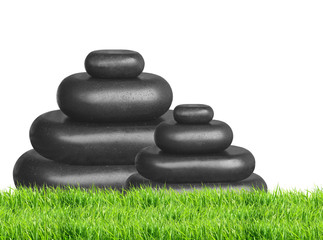 Spa stones in green grass isolated on white