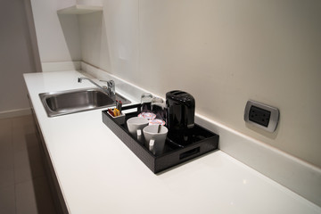 Coffeemaker and cup of coffee in kitchen interior