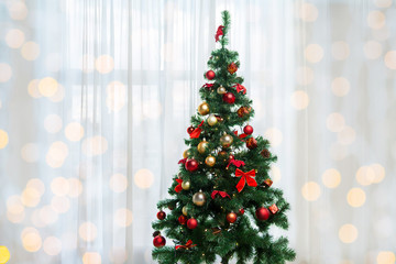christmas tree in living room over window curtain