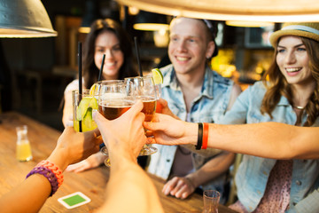 happy friends clinking glasses at bar or pub