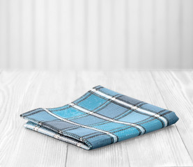 Blue cloth napking on white wooden background with empty space