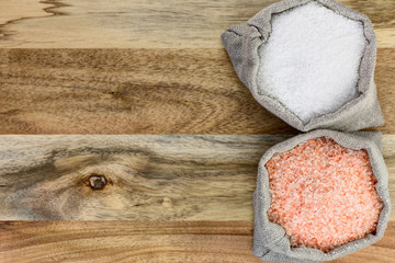 Sea salt and pink salt in the linen sacks on the wooden background