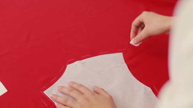 Fashion designer draws a line on the fabric. Seamstress working at home studio. Close Up