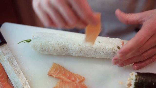 chef in restaurant preparing and Cutting sushi rolls healthy food 