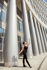 Beautiful graceful ballerina dancing in the front of the buildin