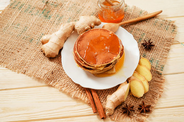 hearty and healthy breakfast , American pancakes with honey , ginger , cinnamon and spices on a...